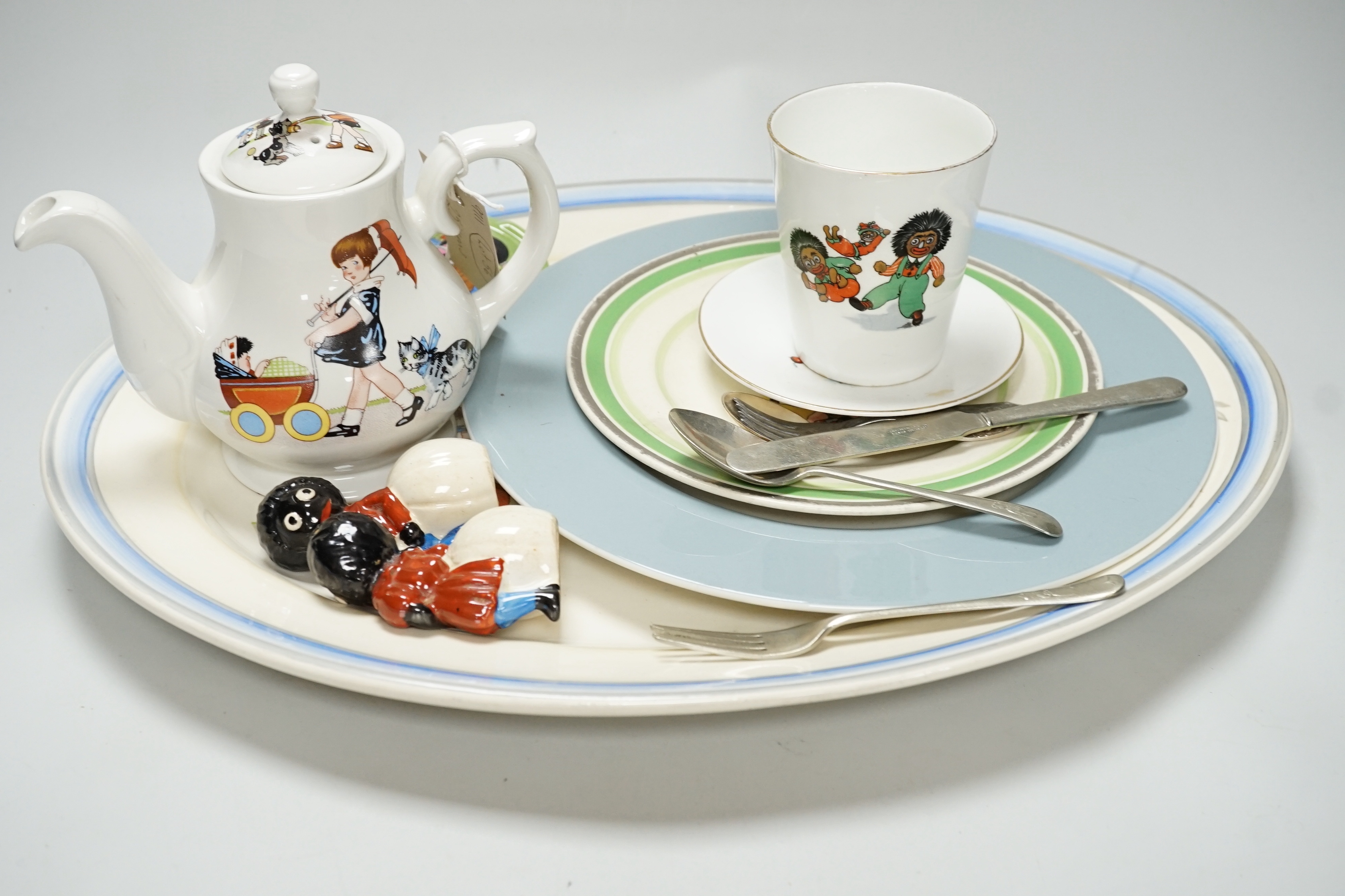 A quantity of golly china to include early green golly and a wooden doll part tea set